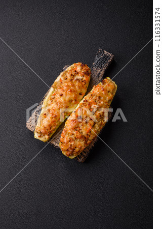 Zucchini halves baked with cheese, tomatoes, meat or meat substitute Zucchini halves baked with cheese, tomatoes, meat or meat substitute 116331574