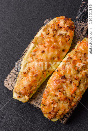 Zucchini halves baked with cheese, tomatoes, meat or meat substitute Zucchini halves baked with cheese, tomatoes, meat or meat substitute 116331586