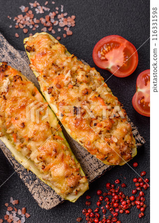 Zucchini halves baked with cheese, tomatoes, meat or meat substitute Zucchini halves baked with cheese, tomatoes, meat or meat substitute 116331598