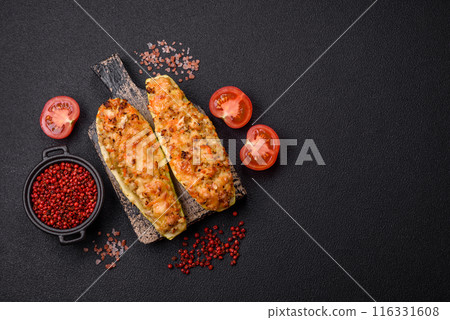 Zucchini halves baked with cheese, tomatoes, meat or meat substitute Zucchini halves baked with cheese, tomatoes, meat or meat substitute 116331608