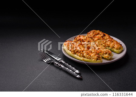 Zucchini halves baked with cheese, tomatoes, meat or meat substitute 116331644