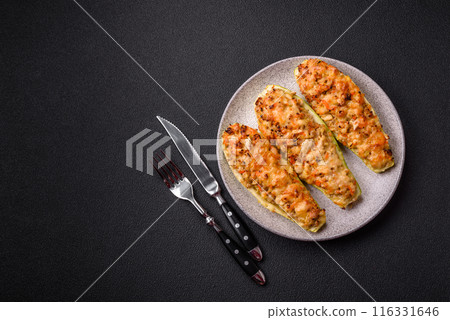 Zucchini halves baked with cheese, tomatoes, meat or meat substitute 116331646