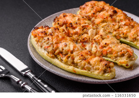 Zucchini halves baked with cheese, tomatoes, meat or meat substitute Zucchini halves baked with cheese, tomatoes, meat or meat substitute 116331650
