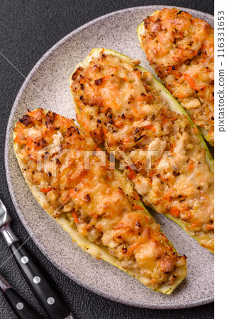 Zucchini halves baked with cheese, tomatoes, meat or meat substitute 116331653