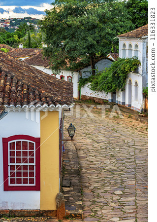 Stone-paved street and old colonial houses 116331823