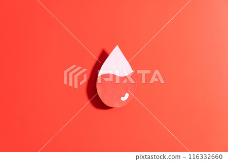 Blood drop with low blood level made from paper on red background. Concept of hematologic disorders such as anemia, sickle cell disease, hemophilia, leukemia and ITP. 116332660