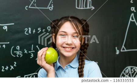 A teenage schoolgirl took out apples for a snack during a break between lessons 116333553