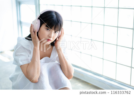 聽到與耳機的音樂的一個少婦 116333762