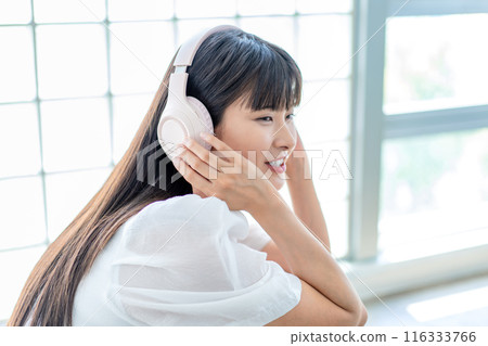 A young woman listening to music with headphones 116333766