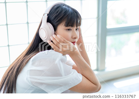聽到與耳機的音樂的一個少婦 116333767