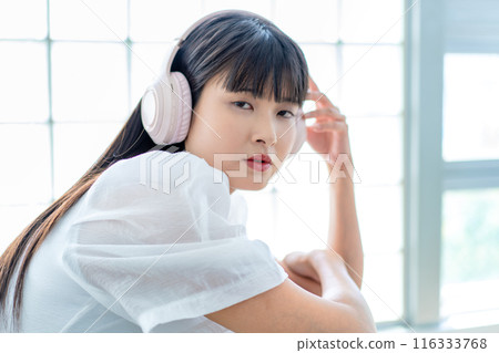 聽到與耳機的音樂的一個少婦 116333768