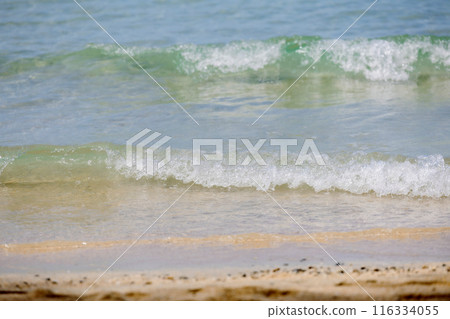 Soft wave of ocean on sandy beach. Wave of the sea on the sand beach. White sand beach and blue sky Soft wave of ocean on sandy beach. Wave of the sea on the sand beach. White sand beach and blue sky 116334055