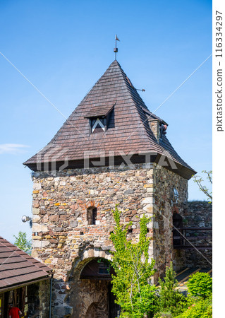 A view of the gate tower at Potstejn Castle Ruins in Czechia, with its stone walls, wooden roof, and a small window. 116334297