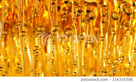 Freeze Motion Shot of Splashing Oil on Golden Background 116335586