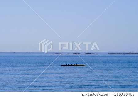 An outrigger canoe glides smoothly across the ocean An outrigger canoe glides smoothly across the ocean 116336495