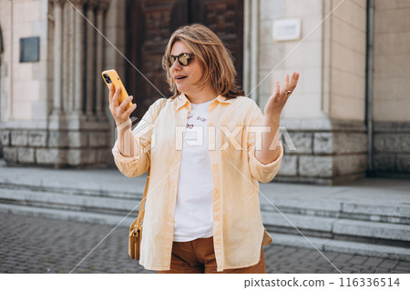Upset sad, skeptical, serious woman holding smartphone gadget for communicate outdoors. Negative people emotion, Urban lifestyle concept. Angry 30s girl reading bad news 116336514
