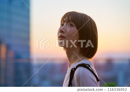 Portrait of a young woman standing in the city during magic hour Portrait of a young woman standing in the city during magic hour 116336952