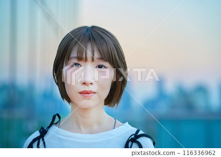 魔法時刻站在城市的年輕女子的肖像 116336962