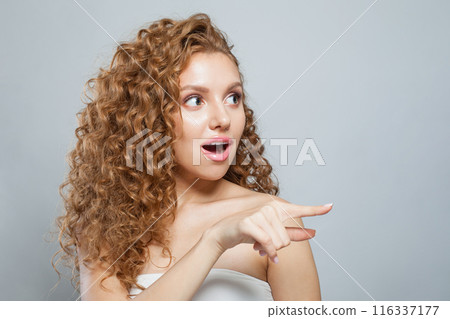 Surprised woman pointing finger on white background with copy space Surprised woman pointing finger on white background with copy space 116337177