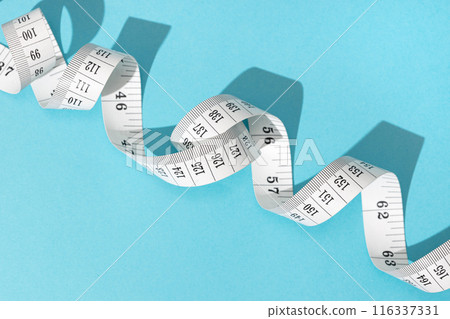 Measuring tape on blue background. Weight or length concept 116337331