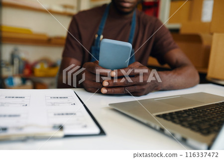 Man Using His Smartphone At Work 116337472