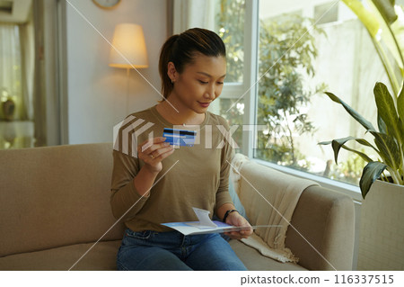 Woman Reading Bank Letter At Home 116337515