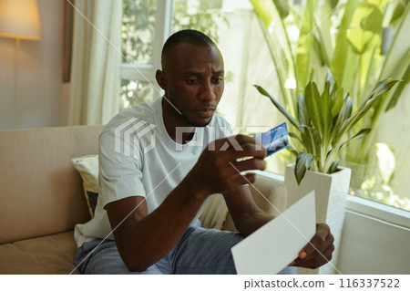Man Opening Letter With Credit Card 116337522