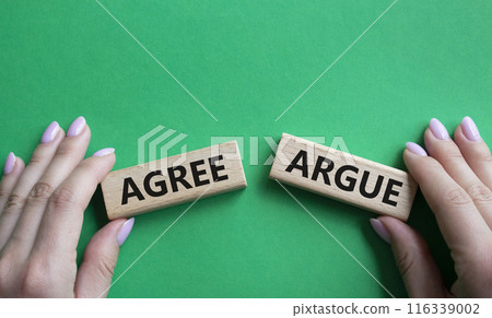Agree or Argue symbol. Concept word Agree or Argue on wooden blocks. Businessman hand. Beautiful green background. Gender and Agree or Argue concept. Copy space Agree or Argue symbol. Concept word Agree or Argue on wooden blocks. Businessman hand. Beautiful green background. Gender and Agree or Argue concept. Copy space 116339002