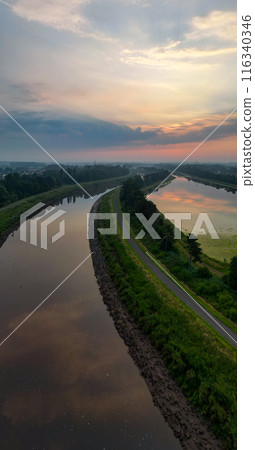 The scenery of the river bending at sunset is peaceful, with serene waters and a lush landscape The scenery of the river bending at sunset is peaceful, with serene waters and a lush landscape 116340346