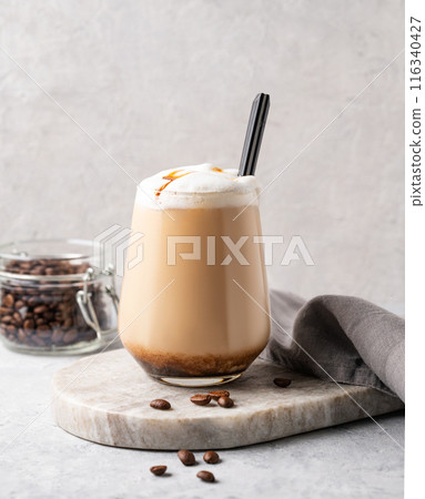 Cappuccino or latte with milk foam and caramel in a glass with coffee beans Cappuccino or latte with milk foam and caramel in a glass with coffee beans 116340427