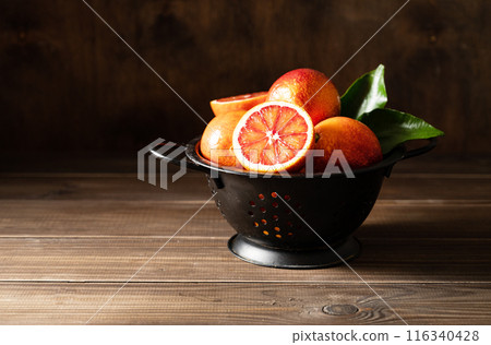 Juicy sicilian red oranges in a black bowl on a dark wooden background. Front view and copy space Juicy sicilian red oranges in a black bowl on a dark wooden background. Front view and copy space 116340428