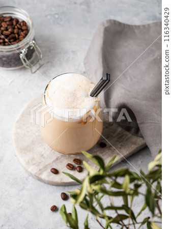 Cappuccino or latte with milk foam in a glass with coffee beans on light  marble background  116340429