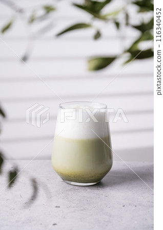 Japanese matcha latte, green tea with soy milk in glass on light background with branches Japanese matcha latte, green tea with soy milk in glass on light background with branches 116340452