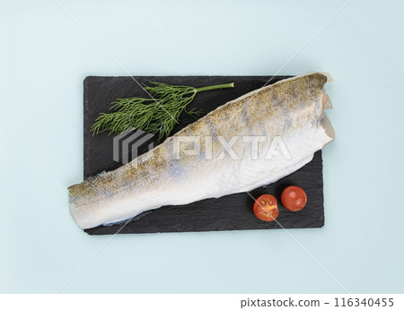 Raw pike perch fillet with fresh cherry tomatoes and a branch of dill on a black slate  116340455