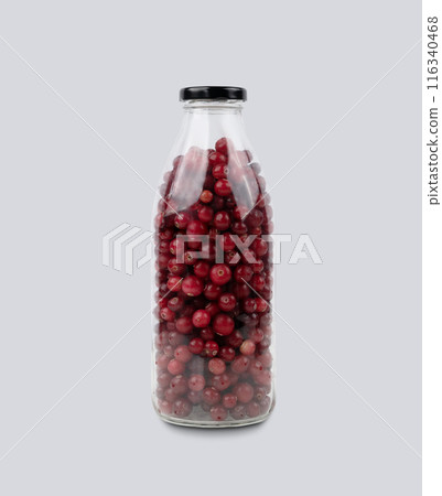 Bottle with wild cranberries and lingonberries on a gray isolated background. Healthy drink concept. Bottle with wild cranberries and lingonberries on a gray isolated background. Healthy drink concept. 116340468
