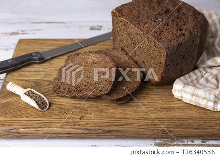 Rye Borodino (Borodinskiy) bread with a crispy crust on a wooden board, cut into slices. Homemade baking in rustic style. Selective focus, close-up. Rye Borodino (Borodinskiy) bread with a crispy crust on a wooden board, cut into slices. Homemade baking in rustic style. Selective focus, close-up. 116340536
