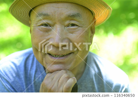 Smiling old man walking with a cane 116340650