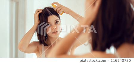 Girl applies a balm on her hair. Girl applies a balm on her hair. 116340720