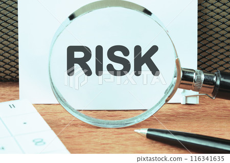 Risk management concept. RISK word written through a magnifying glass on a clean white sheet Risk management concept. RISK word written through a magnifying glass on a clean white sheet 116341635