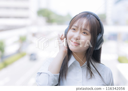 High school girls listening to music in the city 116342056