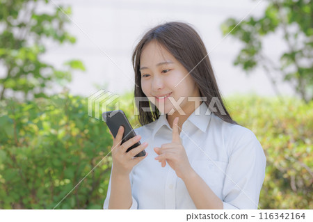 坐在城市裡使用智慧型手機的高中女孩 116342164