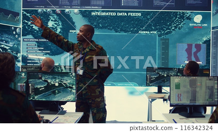 Major general updating and maintain the command center databases with current operational data, monitoring surveillance radar footage to ensure national safety. Control room. Camera B. Major general updating and maintain the command center databases with current operational data, monitoring surveillance radar footage to ensure national safety. Control room. Camera B. 116342324