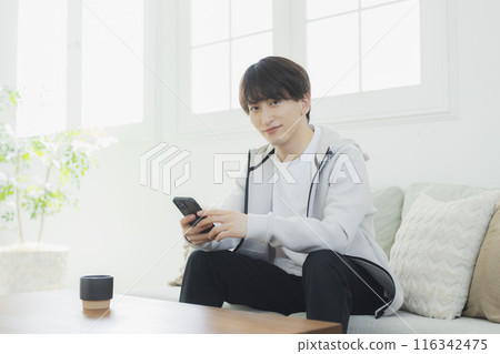 Young man relaxing in the living room Young man relaxing in the living room 116342475
