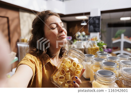 Influencer making internet video for social media, presenting eco friendly zero waste store. Sustainable lifestyle vlogger filming herself inside bulk products local grocery shop Influencer making internet video for social media, presenting eco friendly zero waste store. Sustainable lifestyle vlogger filming herself inside bulk products local grocery shop 116342601