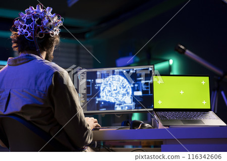 Isolated screen laptop and man with EEG headset doing brain transfer into virtual world, merging with artificial intelligence. Admin using neuroscience and chroma key notebook to gain digital soul Isolated screen laptop and man with EEG headset doing brain transfer into virtual world, merging with artificial intelligence. Admin using neuroscience and chroma key notebook to gain digital soul 116342606