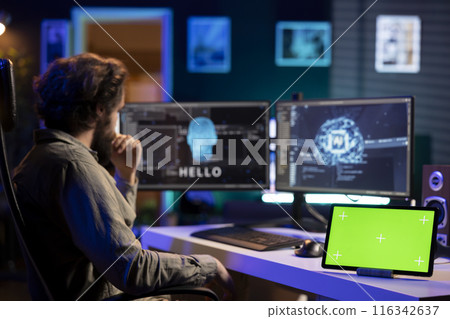 Programmer being asked existential questions by awaken AI gaining consciousness next to chroma key tablet. Man communicating with artificial intelligence through isolated screen device 116342637
