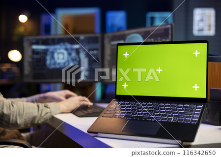 Green screen laptop next to man updating artificial intelligence neural networks, writing binary code script. IT professional upgrading high tech AI, mockup notebook on desk, close up 116342650