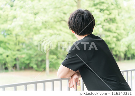 穿著運動服的亞洲年輕男子看著公園的景色 穿著運動服的亞洲年輕男子看著公園的景色 116343351