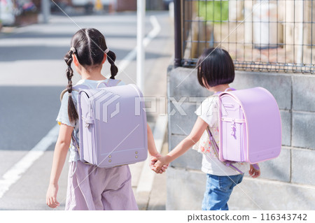 Elementary school students carrying backpacks to and from school Elementary school students carrying backpacks to and from school 116343742