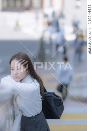A high school girl standing in the street with a bag A high school girl standing in the street with a bag 116344481